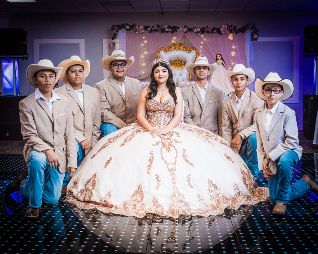 Fotógrafo de Quinceañeras en New Jersey | Vestido Espectacular y Edecanes con Sombrero Quinceañera con majestuoso vestido posando junto a su corte de edecanes con sombrero. Fotografía profesional de fiesta de 15 años en New Jersey.