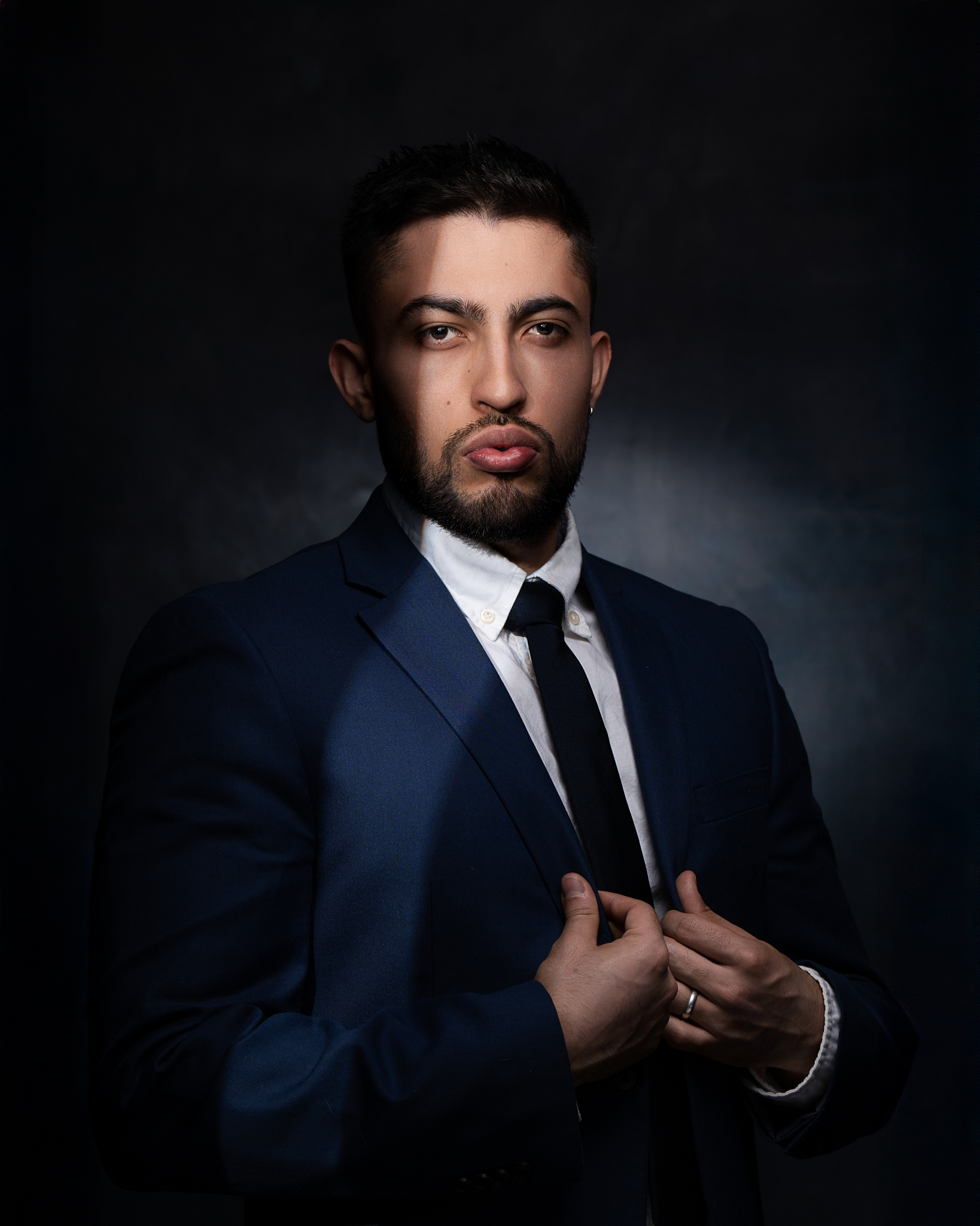 Retrato profesional de un hombre de negocios con traje azul, mirando a la cámara con una expresión de confianza.